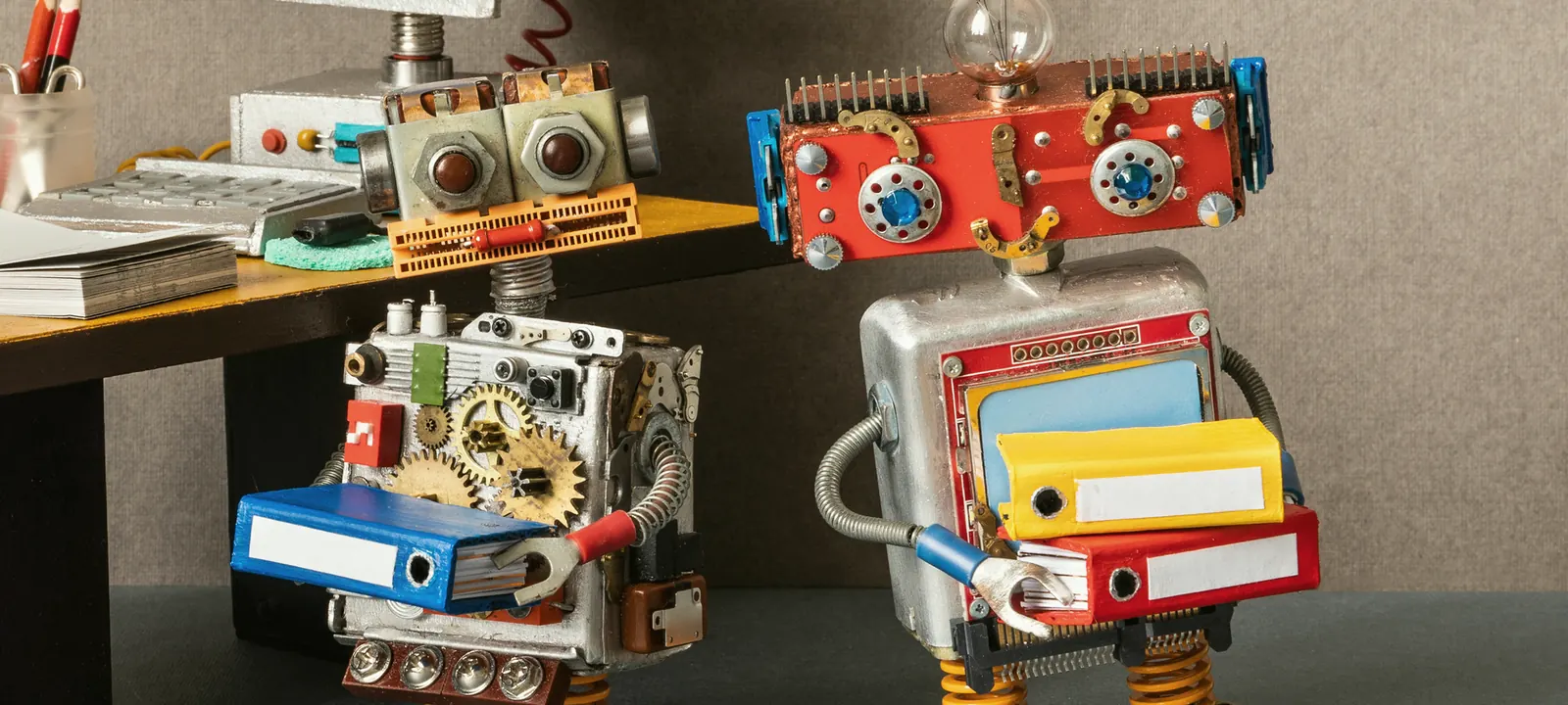 Dwa roboty niosące segregatory z dokumentami — papierowy obieg pod kontrolą